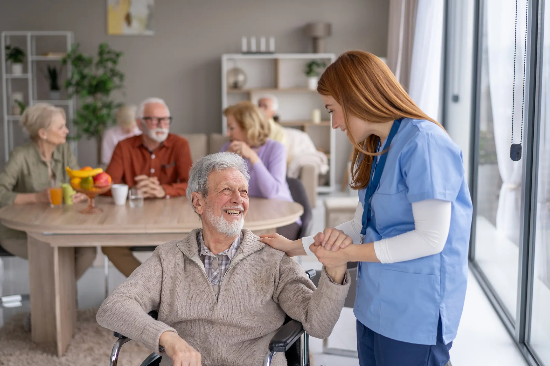Caregiver assisting elderly man in wheelchair.