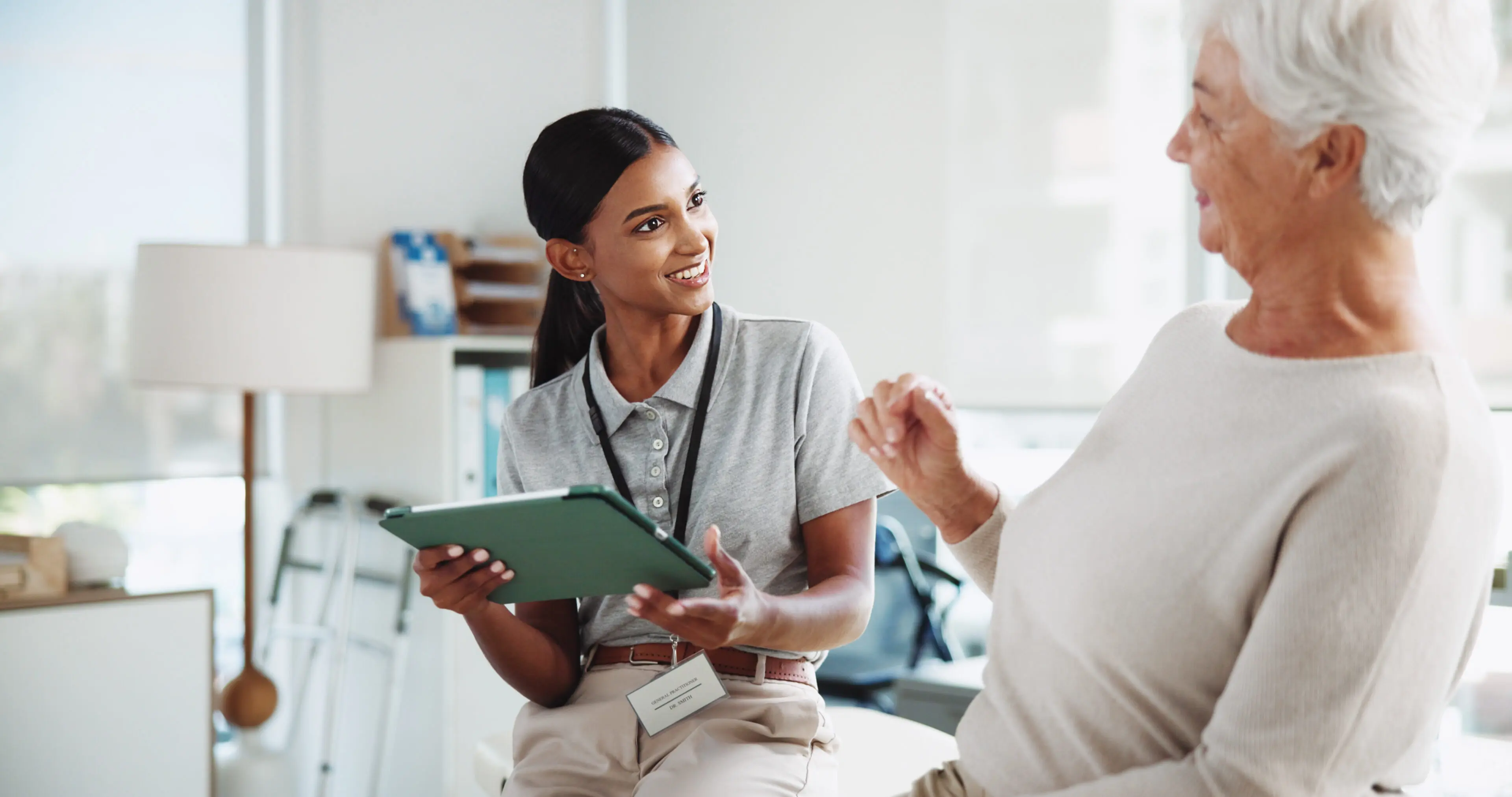Healthcare worker discussing with elderly patient.
