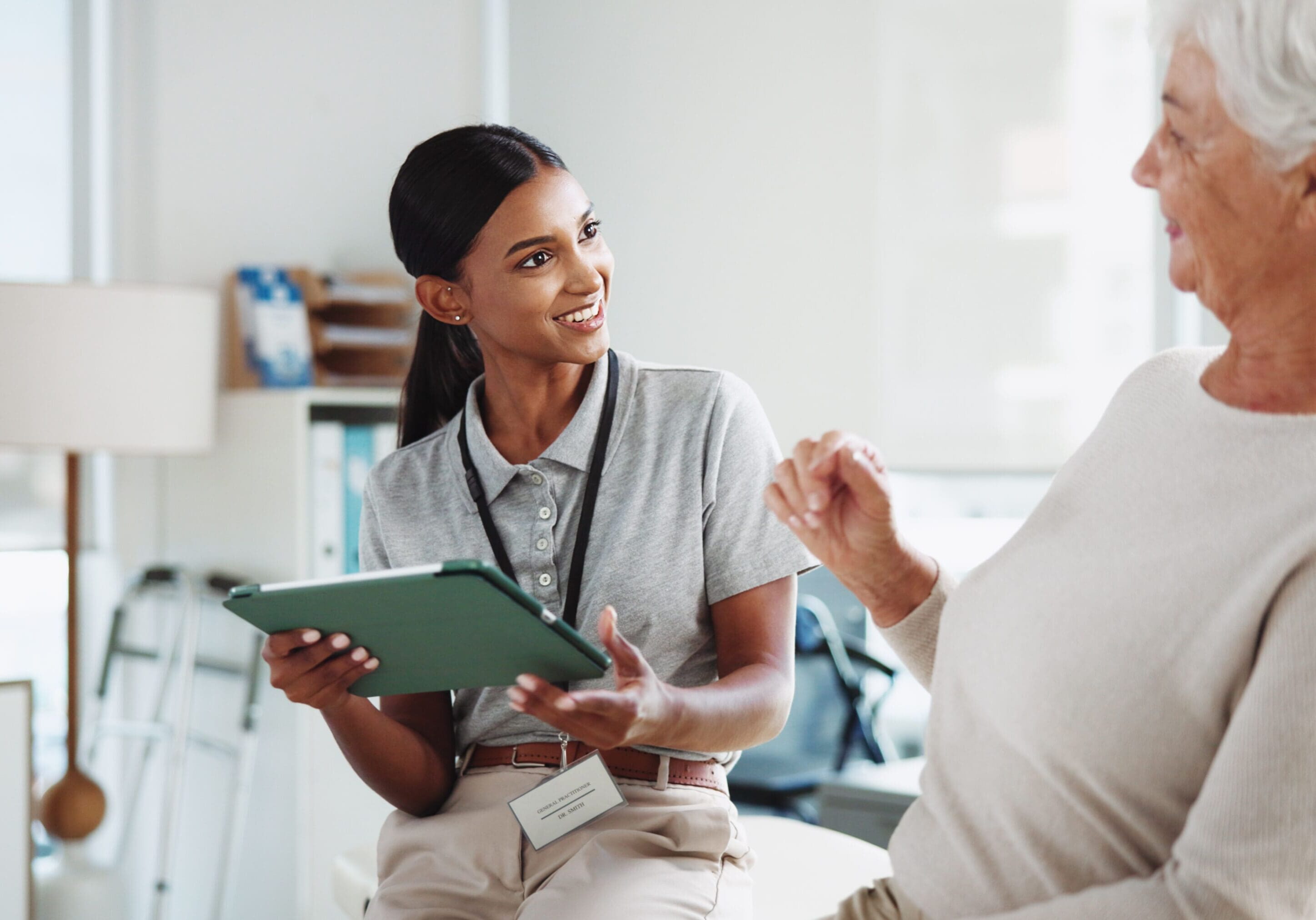 Healthcare worker discussing with elderly patient.